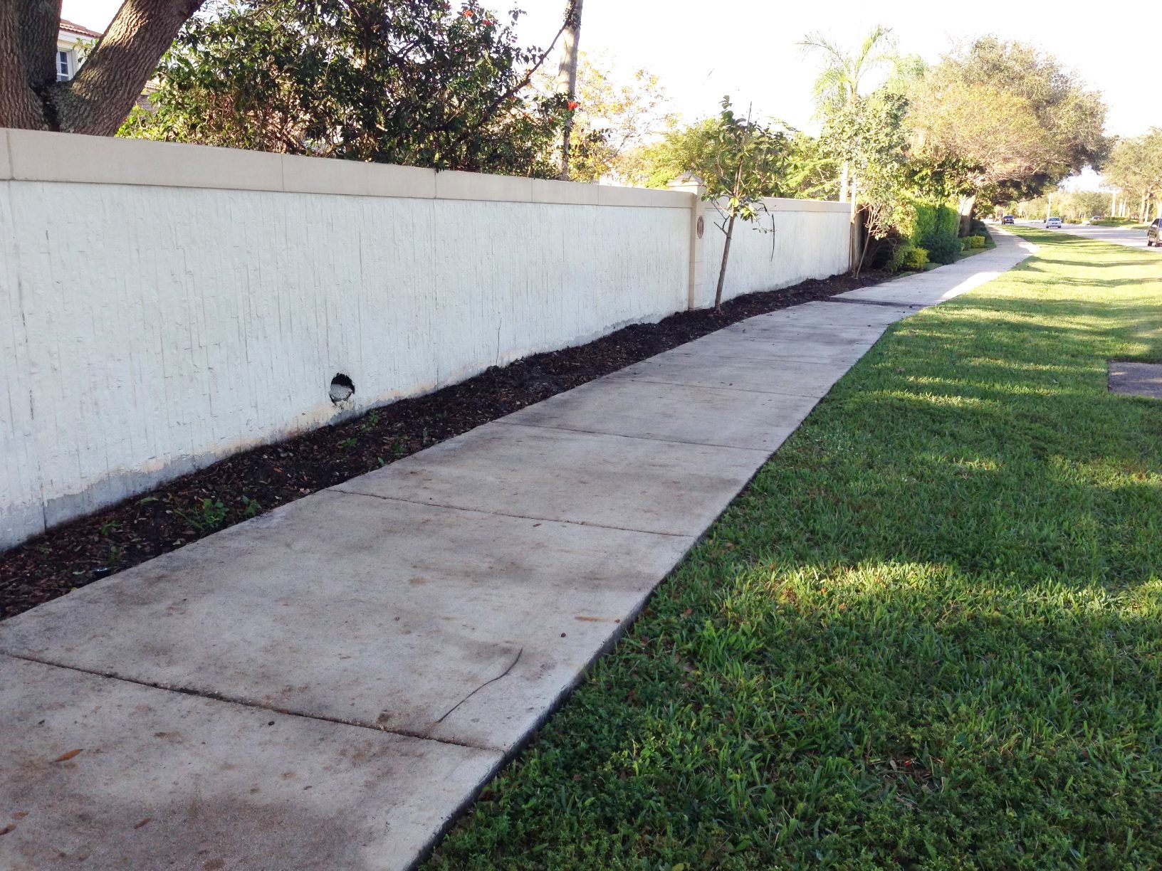 Long white privacy wall and sidewalk cleaned by Aqua Force