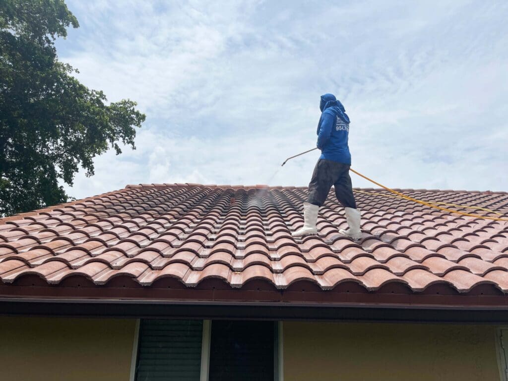 Aqua Force technician soft washing a barrel tile roof in South Florida