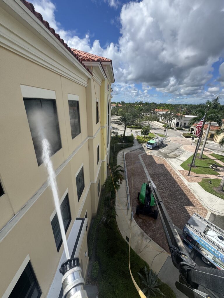 Aqua Force crew washing a three-story wall from a boom lift