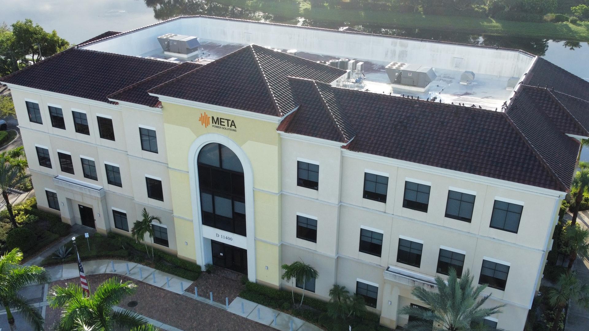 Commercial office building before roof cleaning, with dark algae covering the clay tile roof