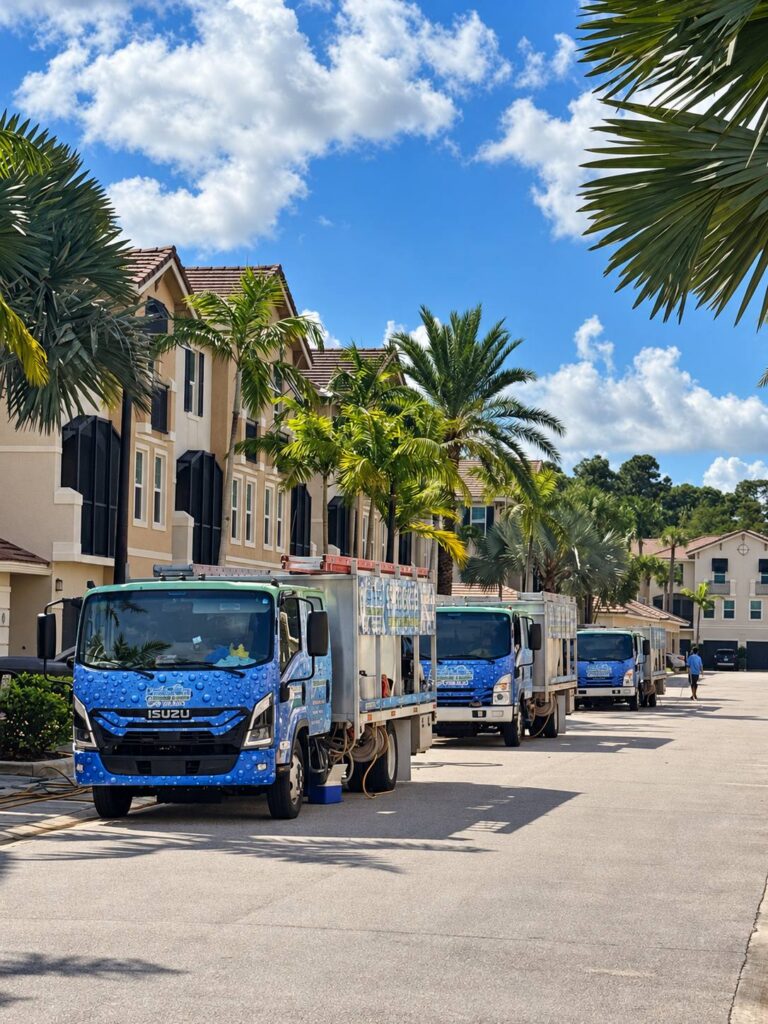 Aqua Force Pressure Cleaning trucks lined up in a South Florida townhome community